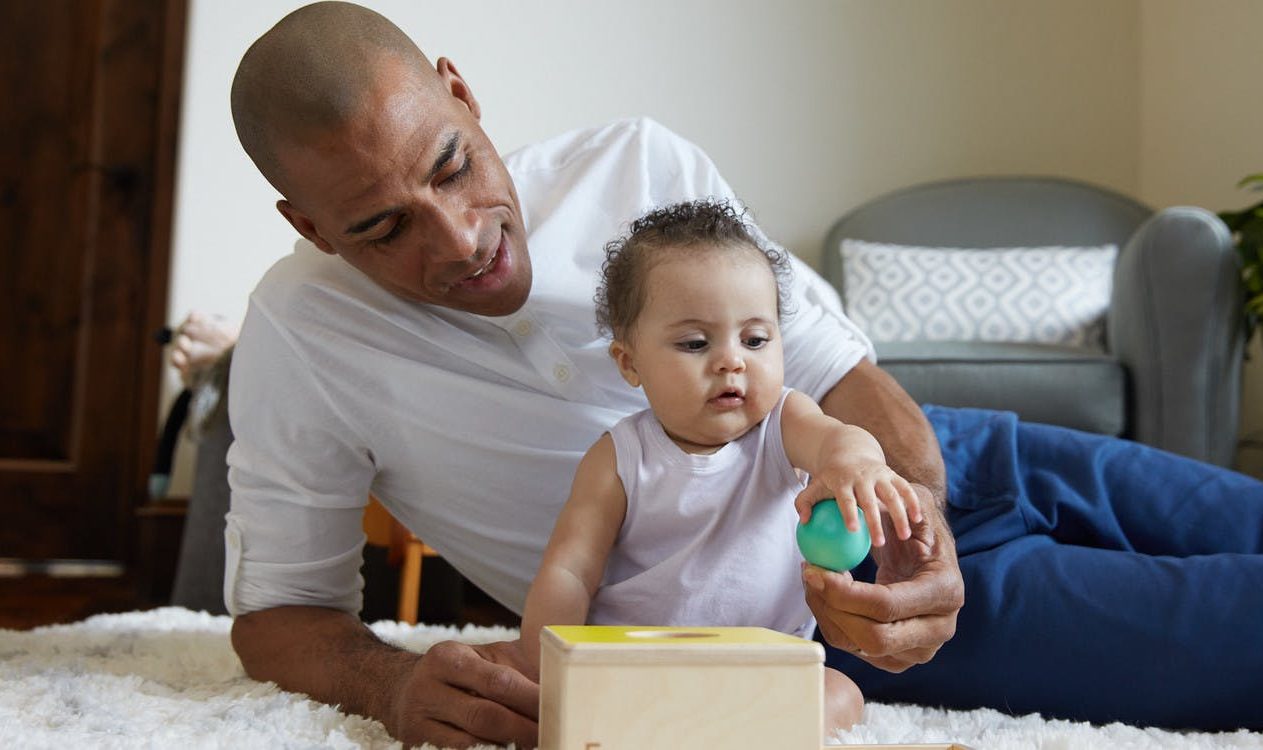 Toddler playing with the Sliding Top Box by Lovevery