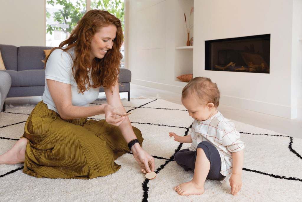 Mother and child playing with wooden coins from Lovevery