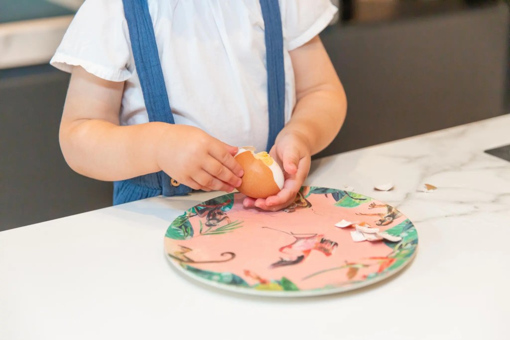 Child peeling an egg