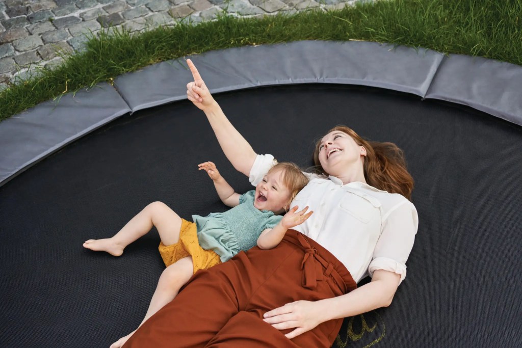 Mother and daughter laying on a trampoline