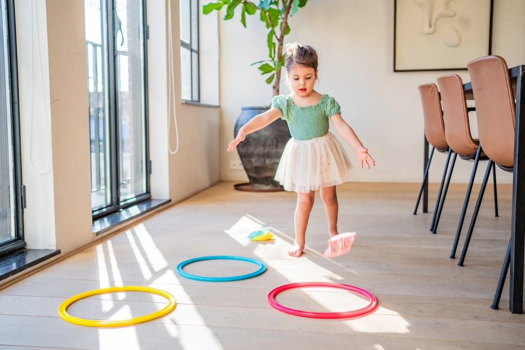 Child playing with the Jump-In Hoops And Bean Bags from The Researcher Play Kit