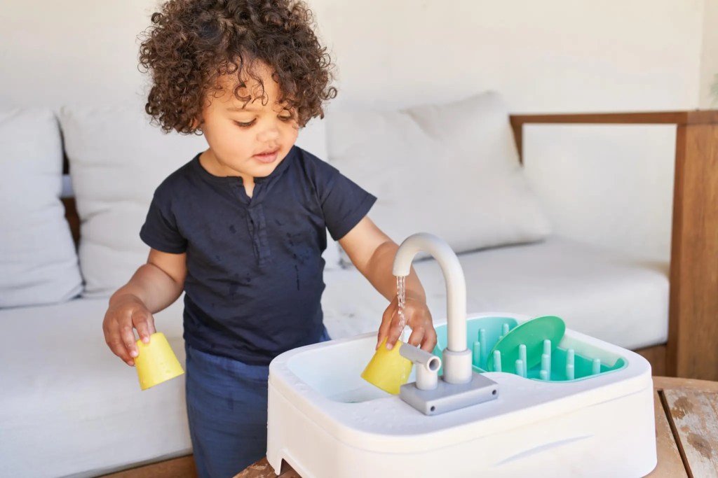 Child playing with the Super Sustainable Sink from The Helper Play Kit