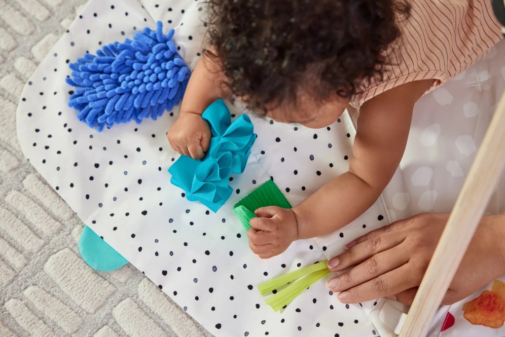 Child playing with the How Things Feel Zone on The Play Gym by Lovevery